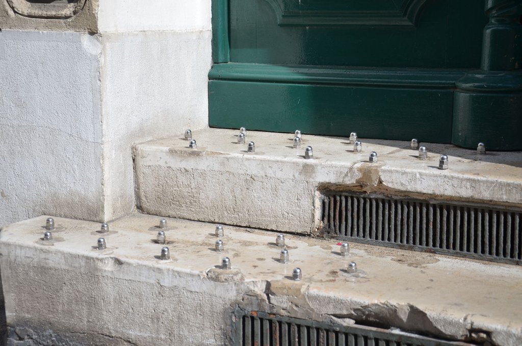 Small metal anti-sitting bumps on building ledge in France